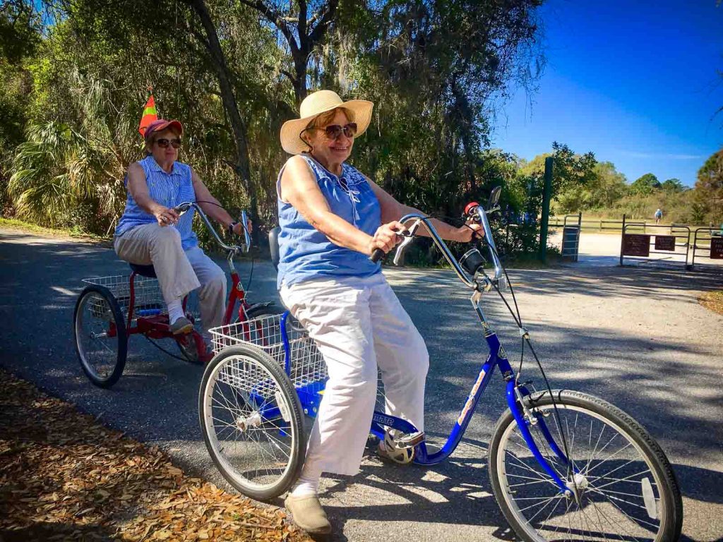 Two ladies on rental trikes from Venice Bikes and Trikes at Oscar Scherer Park on The Legacy Trail